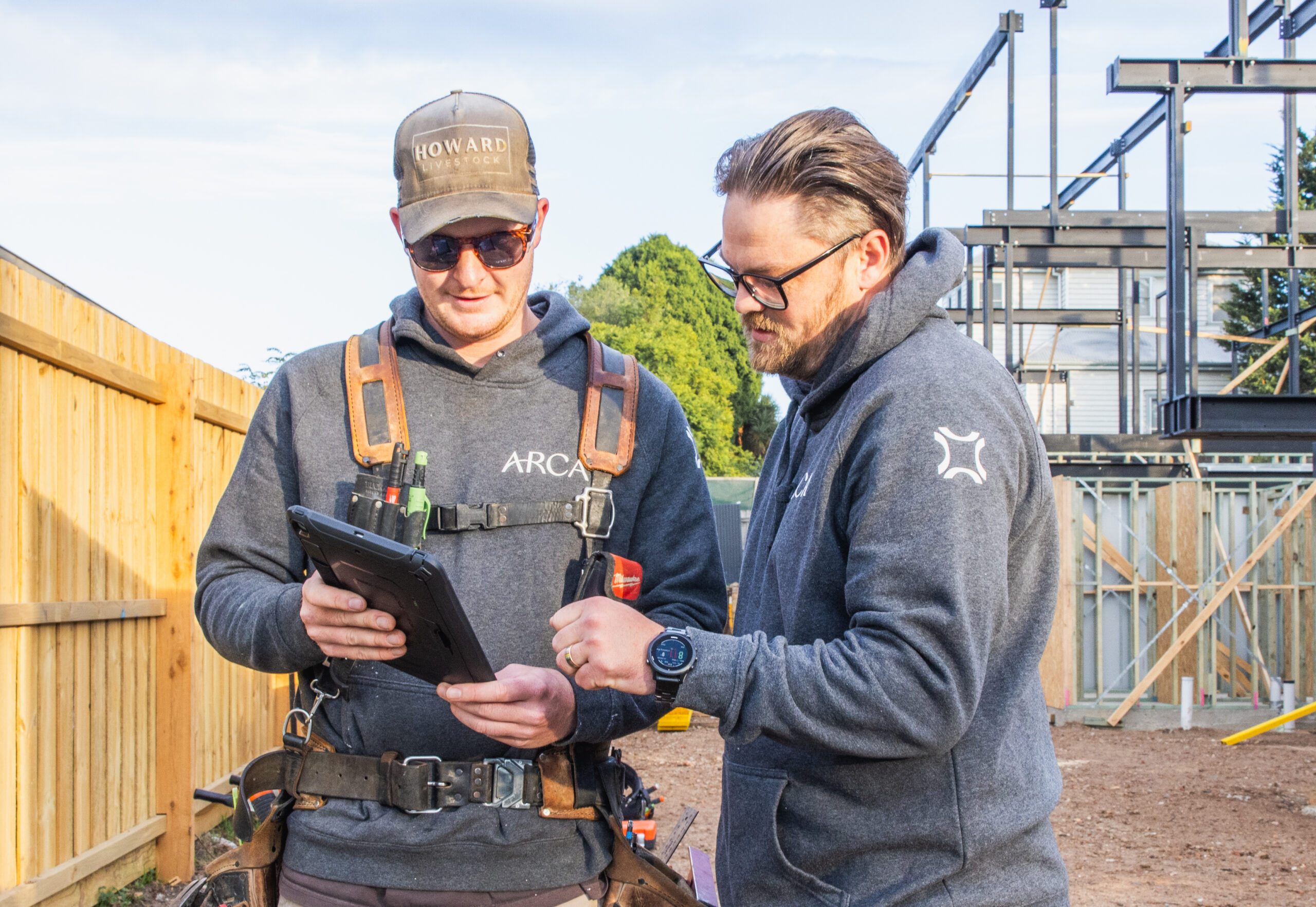Two people using an ipad on a construction site